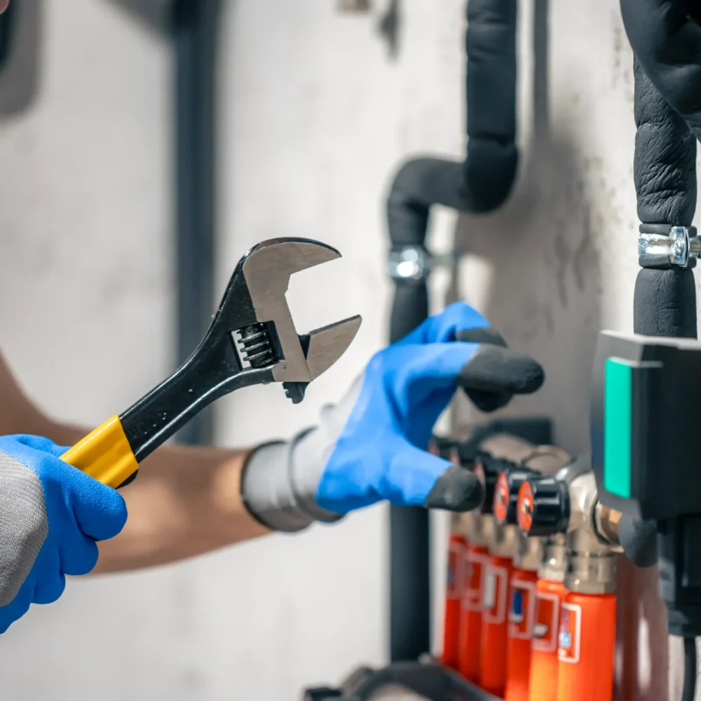 MediaMorph_man-installs-heating-system-house-checks-pipes-with-wrench_min